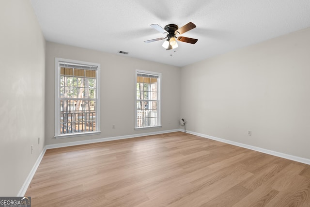 unfurnished room featuring ceiling fan, light hardwood / wood-style flooring, and a textured ceiling