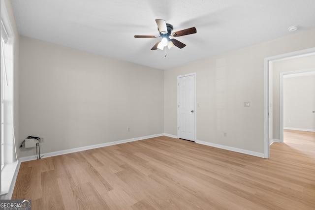 empty room with ceiling fan and light hardwood / wood-style floors