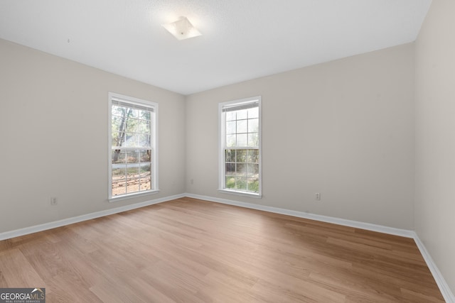 empty room with a healthy amount of sunlight and light wood-type flooring