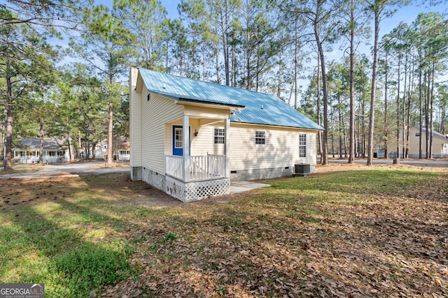 view of side of home featuring a lawn and central air condition unit