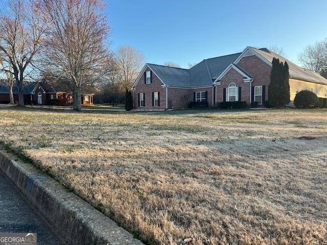 single story home featuring a front lawn