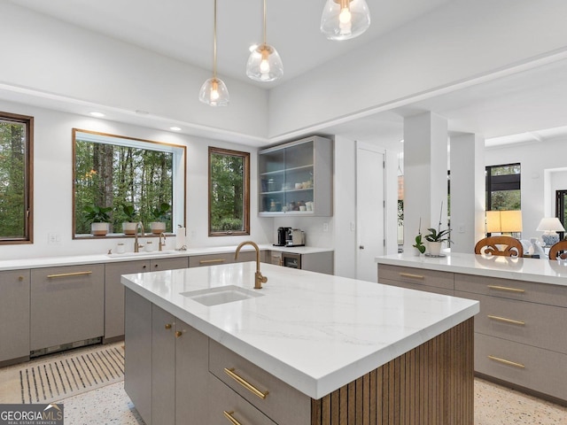 kitchen featuring gray cabinetry, a sink, and light speckled floor