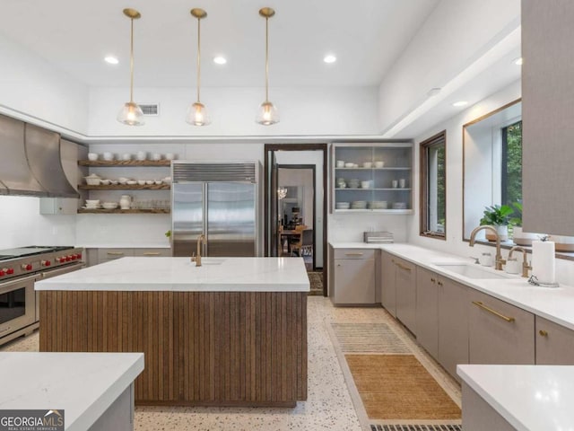 kitchen with a sink, open shelves, high quality appliances, ventilation hood, and visible vents