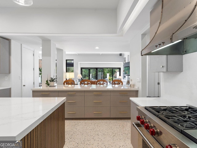 kitchen featuring recessed lighting, under cabinet range hood, high end stainless steel range oven, light speckled floor, and gray cabinets
