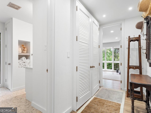 hallway featuring visible vents, light wood-style flooring, and recessed lighting