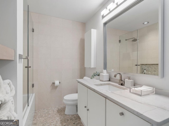 full bathroom featuring toilet, tiled shower, and vanity
