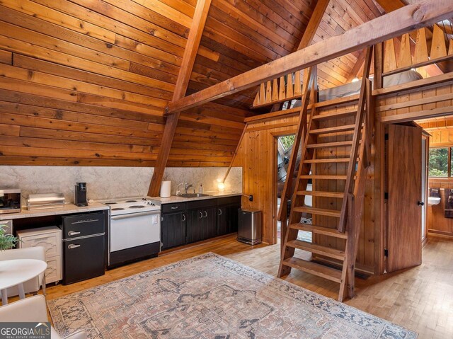 kitchen with a sink, lofted ceiling with beams, wooden walls, white range with electric cooktop, and dark cabinetry
