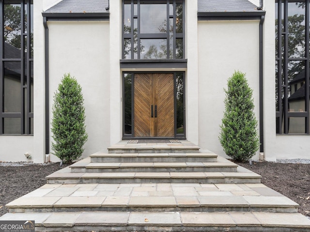 doorway to property featuring stucco siding