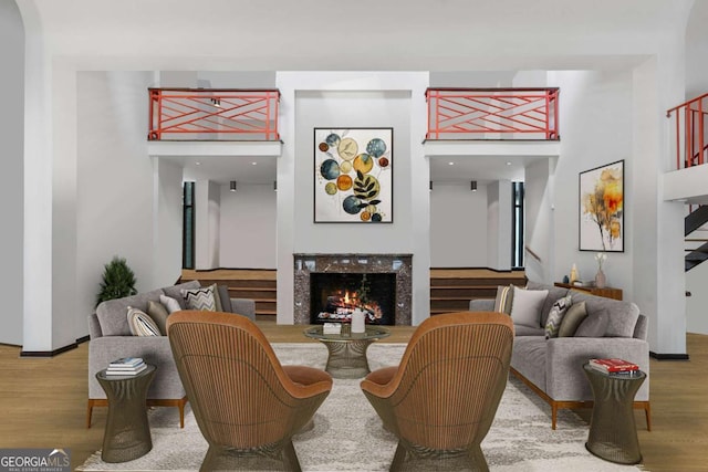 living room featuring a high end fireplace and wood-type flooring