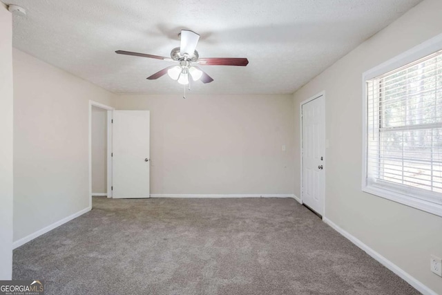 carpeted empty room with ceiling fan and a textured ceiling