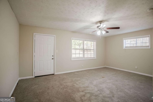 carpeted spare room with ceiling fan and a textured ceiling