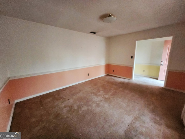 empty room featuring carpet, visible vents, and baseboards