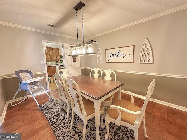 dining area with crown molding and hardwood / wood-style floors