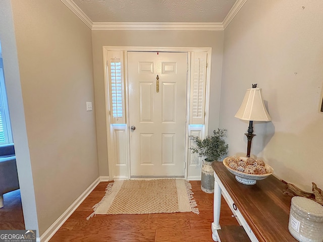 entrance foyer featuring hardwood / wood-style flooring, ornamental molding, and a textured ceiling