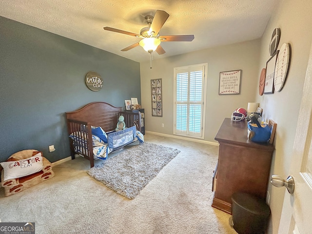 carpeted bedroom with ceiling fan and a textured ceiling