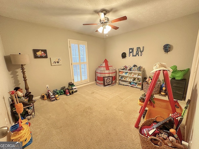 rec room featuring ceiling fan, carpet flooring, and a textured ceiling