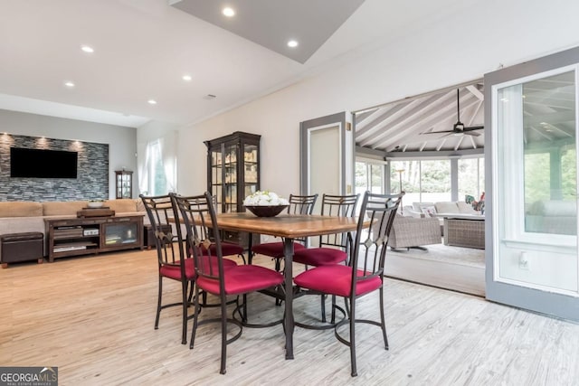 dining space featuring ceiling fan, light hardwood / wood-style floors, and vaulted ceiling