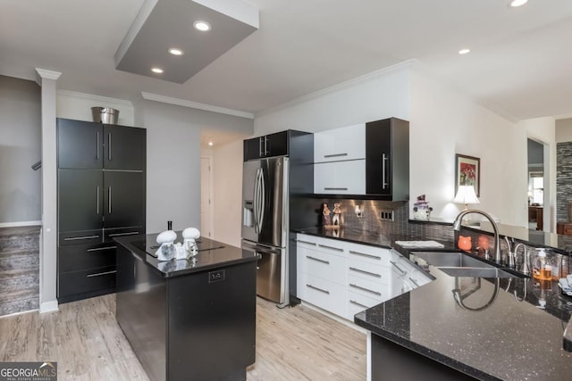 kitchen with stainless steel refrigerator with ice dispenser, a center island, sink, and crown molding