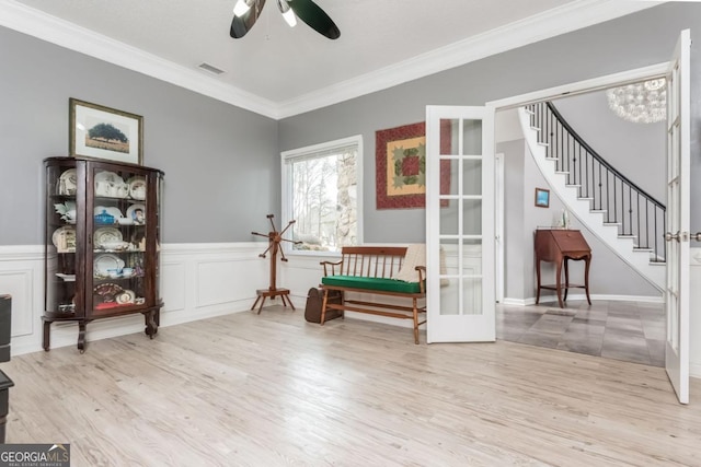 living area with light hardwood / wood-style flooring, ornamental molding, french doors, and ceiling fan