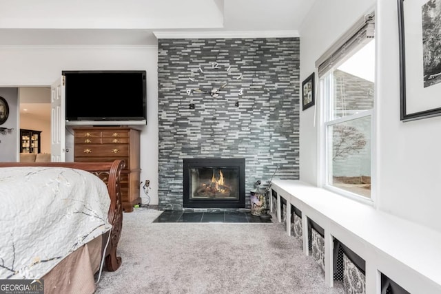 bedroom featuring a tiled fireplace, crown molding, and dark carpet