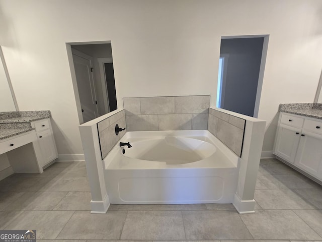 bathroom with tile patterned flooring, vanity, and a tub