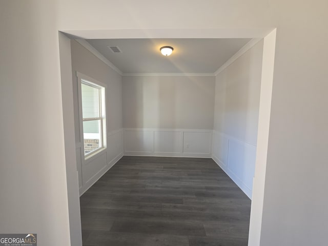 spare room with ornamental molding and dark hardwood / wood-style flooring