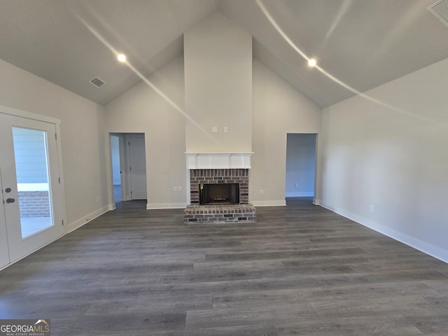 unfurnished living room with dark wood-type flooring, a fireplace, and high vaulted ceiling