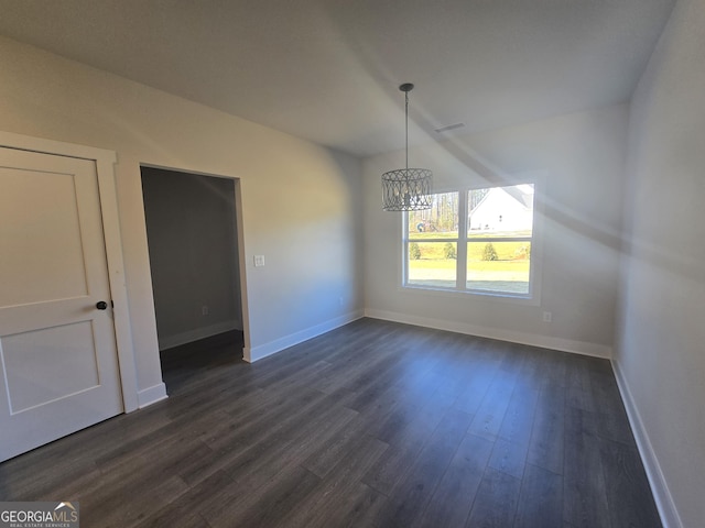 unfurnished dining area with an inviting chandelier and dark hardwood / wood-style floors