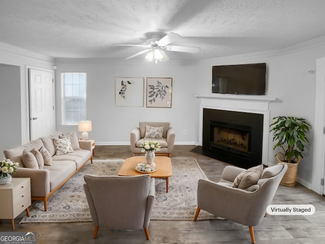 living room featuring crown molding, hardwood / wood-style floors, ceiling fan, and a textured ceiling