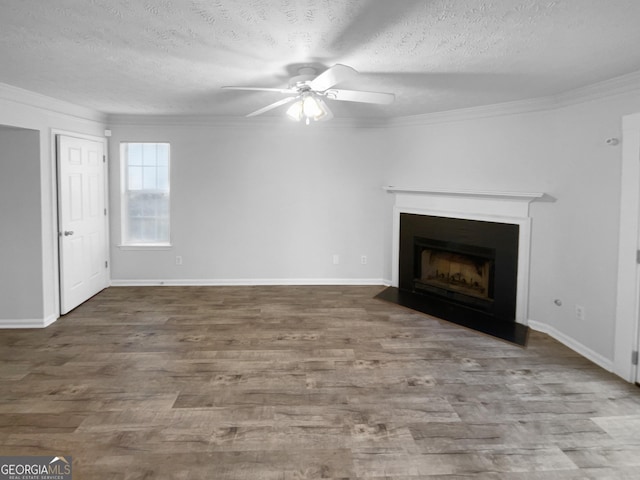 unfurnished living room with hardwood / wood-style flooring, ornamental molding, ceiling fan, and a textured ceiling