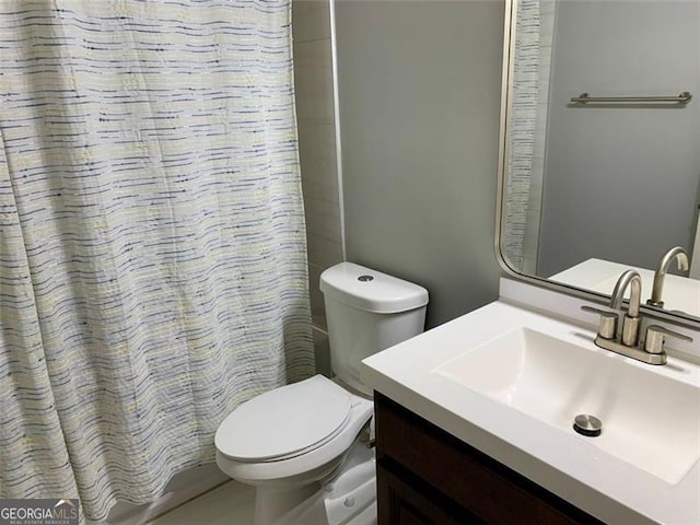 bathroom featuring a shower with curtain, vanity, and toilet