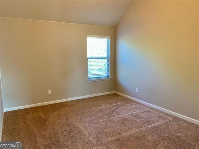 carpeted empty room featuring lofted ceiling