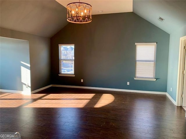 interior space featuring lofted ceiling, dark wood-type flooring, and an inviting chandelier