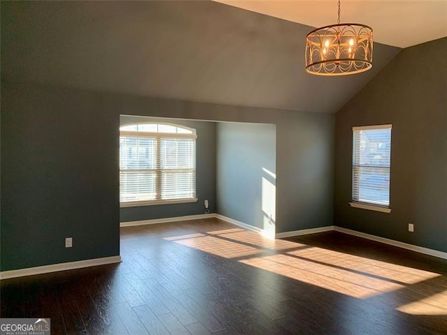 unfurnished living room featuring hardwood / wood-style flooring, vaulted ceiling, and a chandelier