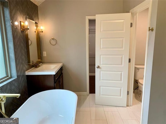 bathroom featuring vanity, tile patterned flooring, a bathing tub, and toilet