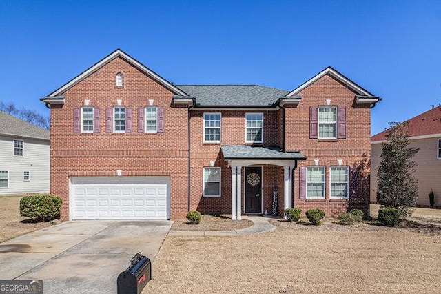 view of front facade with brick siding, an attached garage, and driveway