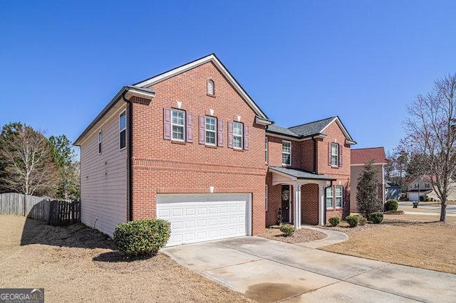 traditional-style home featuring concrete driveway, a garage, fence, and brick siding