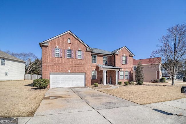 traditional-style house with brick siding, concrete driveway, an attached garage, and fence