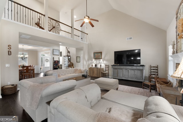 living room featuring hardwood / wood-style flooring, vaulted ceiling, and ceiling fan with notable chandelier