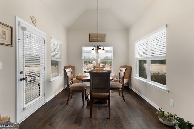 dining area featuring lofted ceiling, dark wood-type flooring, and an inviting chandelier