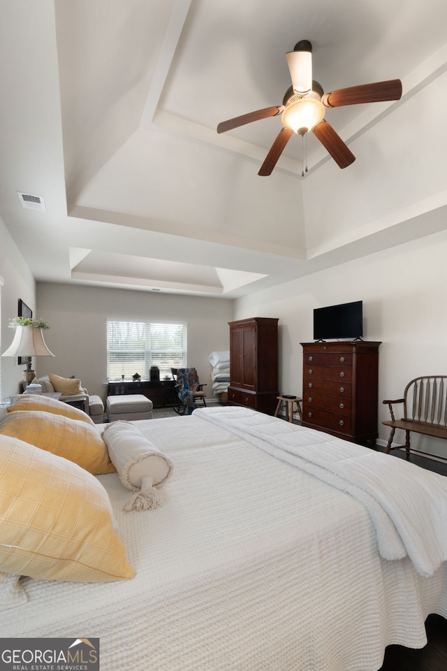 bedroom with a raised ceiling and ceiling fan