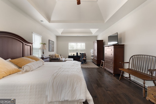 bedroom featuring dark wood-type flooring, ceiling fan, and a raised ceiling