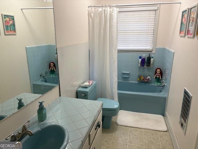 full bathroom featuring vanity, shower / bath combo, tile patterned floors, and toilet