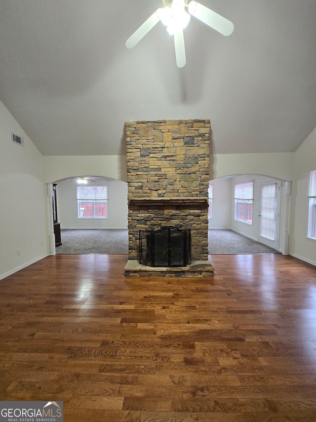 unfurnished living room with dark hardwood / wood-style floors, ceiling fan, a fireplace, and high vaulted ceiling