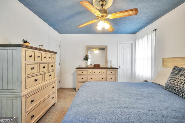 carpeted bedroom with ceiling fan and a textured ceiling