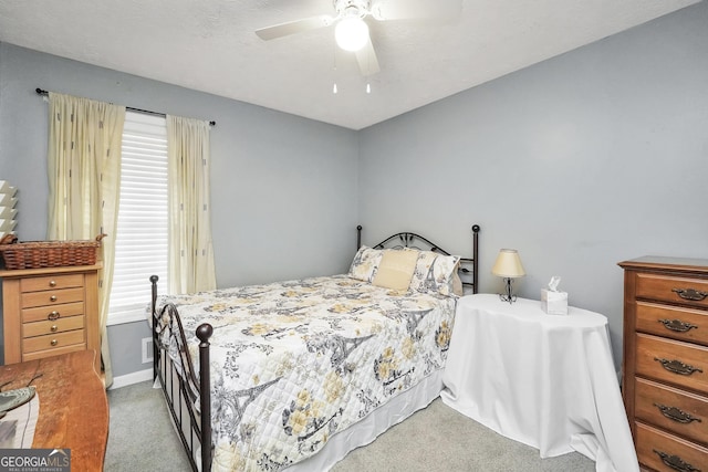 bedroom with ceiling fan, light colored carpet, and multiple windows