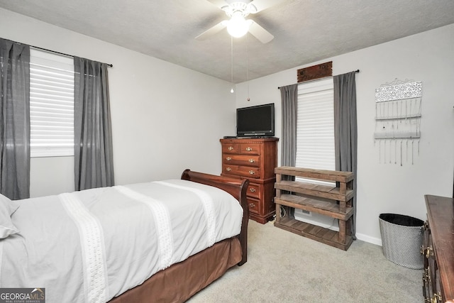 carpeted bedroom featuring a textured ceiling and ceiling fan