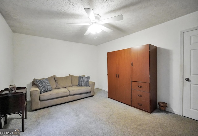 carpeted living room featuring a textured ceiling and ceiling fan