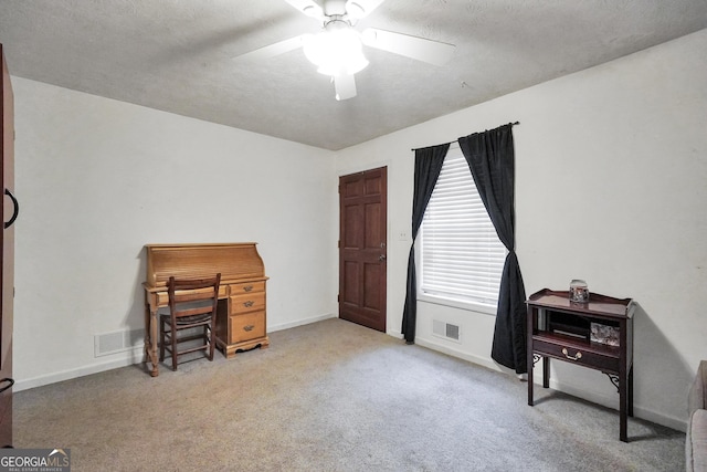 misc room featuring ceiling fan, light colored carpet, and a textured ceiling