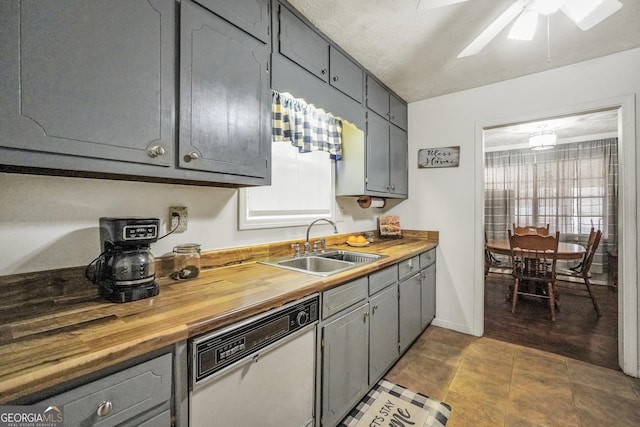 kitchen with sink, gray cabinets, dishwasher, ceiling fan, and butcher block counters